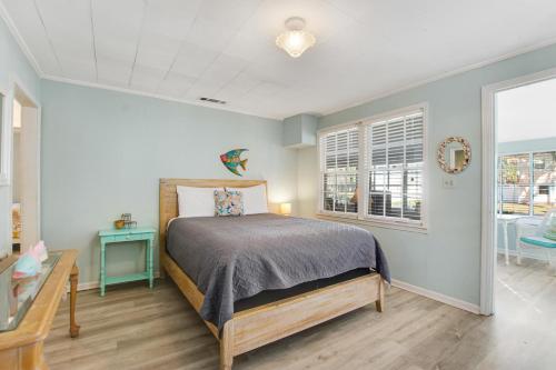 a bedroom with a bed and a table and a window at Beach Cottage on Jones in Tybee Island