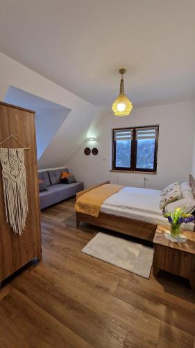 a bedroom with a bed and a couch at Apartamenty U Pana Jana in Wetlina