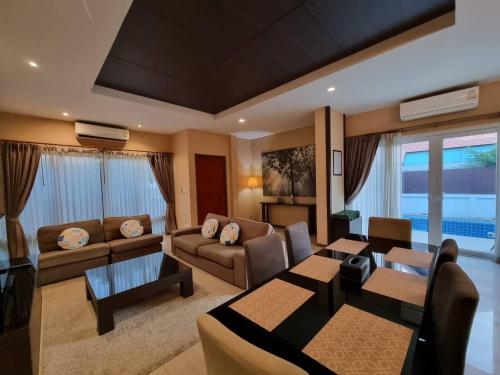 - un salon avec un canapé et une salle à manger dans l'établissement Midas Pool Villa, à Jomtien Beach