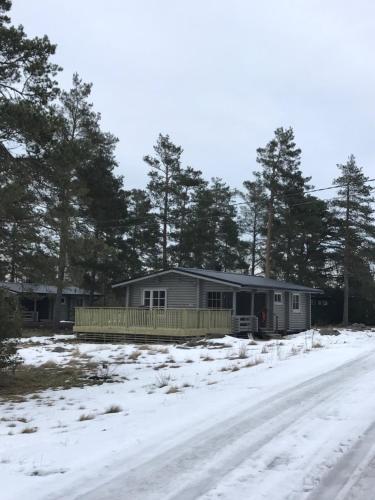 una casa en la nieve al lado de una carretera en Bastöstugby stuga 17, en Pålsböle