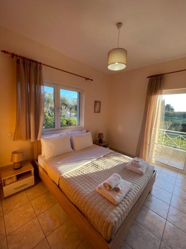 1 dormitorio con 1 cama con toallas en Villa Amarena, en Mitikas