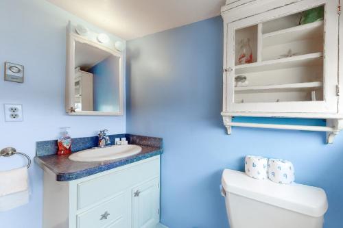 a bathroom with a toilet and a sink and a mirror at The Cottage at Long Sands in York