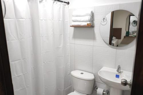 a bathroom with a toilet and a sink and a mirror at Ayenda Hotel Helenas in Ríohacha