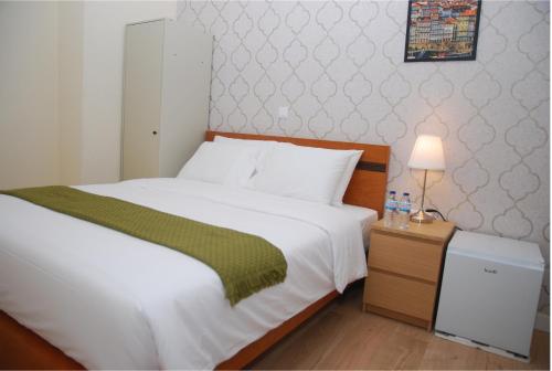 a bedroom with a bed and a night stand with a lamp at Amor Lisboa Hostel in Lisbon
