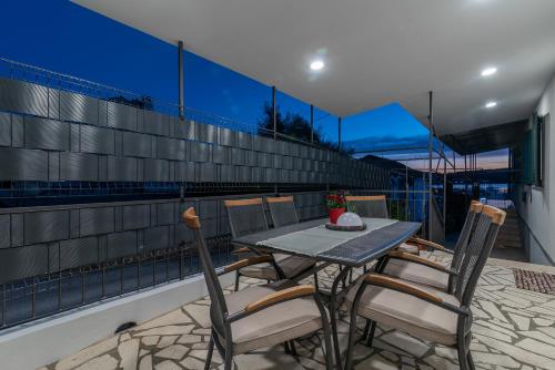 een tafel en stoelen op het balkon van een huis bij Apartment Radić-perfect location for summer activities in Trogir