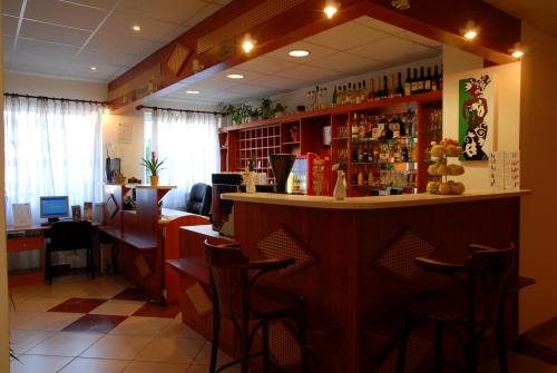a bar in a restaurant with a counter and chairs at Hotel Ferihegy in Vecsés