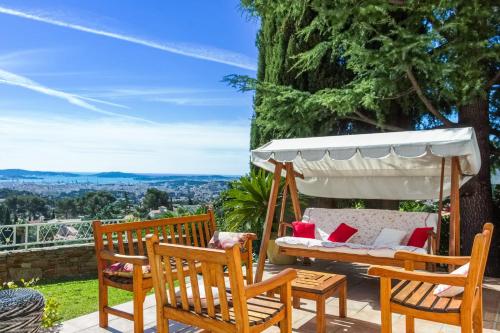 eine Terrasse mit Stühlen, einem Tisch und einer Schaukel in der Unterkunft Maison du Baou - Welkeys in Toulon