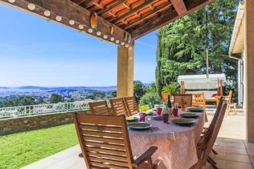 ein Esszimmer mit einem Tisch und Stühlen auf einer Terrasse in der Unterkunft Maison du Baou - Welkeys in Toulon