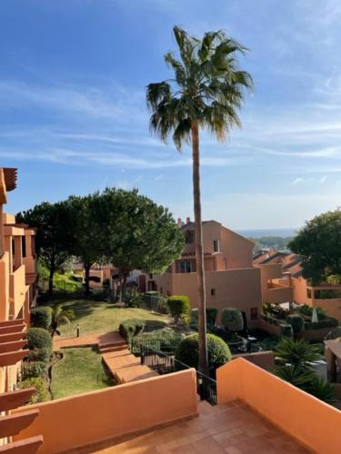 uma palmeira sentada ao lado de um edifício em Marbella Elviria apartment em Marbella