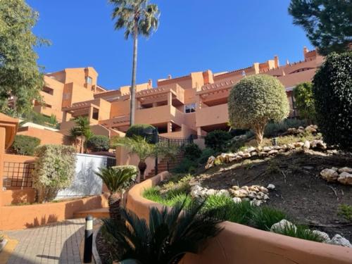 a large building with a garden in front of it at Marbella Elviria apartment in Marbella