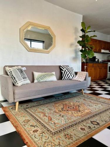 a living room with a couch and a mirror at Casa Carlota in Tijuana