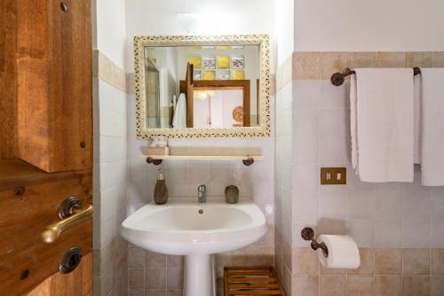 a bathroom with a sink and a mirror at Estia - In Parulia Country House in Arezzo