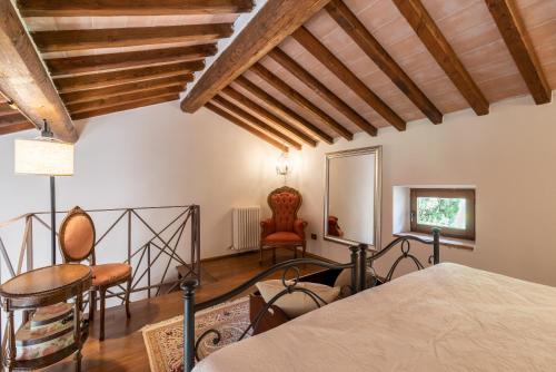 1 dormitorio con 1 cama y sillas en una habitación en Estia - In Parulia Country House, en Arezzo