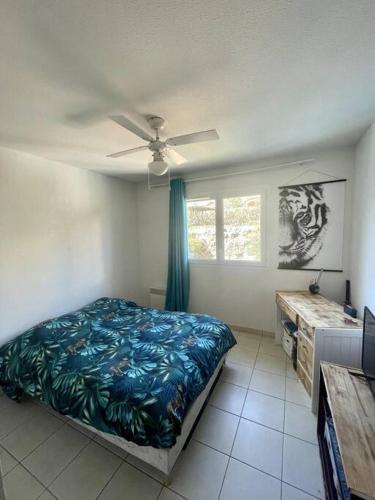 une chambre avec un lit et un ventilateur de plafond dans l'établissement Charmante maison vue mer piscine, à Roquebrune-sur Argens