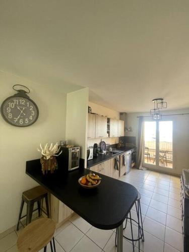 une cuisine avec un comptoir et une horloge au mur dans l'établissement Charmante maison vue mer piscine, à Roquebrune-sur Argens