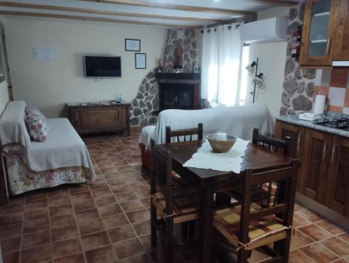 ein Wohnzimmer mit einem Tisch und einem Kamin in der Unterkunft Apartamentos El Callejón in Riópar