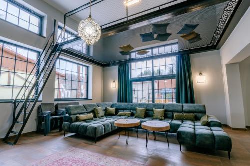 a living room with a green couch and tables at vila FABRIKA in Vyhne