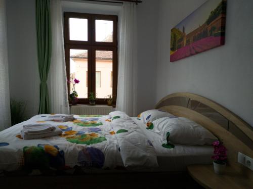 a bedroom with a bed with white sheets and a window at Fanea Residence in Sibiu