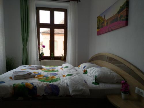 ein Schlafzimmer mit einem Bett mit weißen Laken und einem Fenster in der Unterkunft Fanea Residence in Sibiu