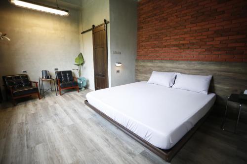 a large white bed in a room with a brick wall at Walking Island in Xiaoliuqiu