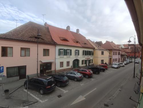 eine Stadtstraße mit auf einem Parkplatz geparkten Autos in der Unterkunft Fanea Residence in Sibiu