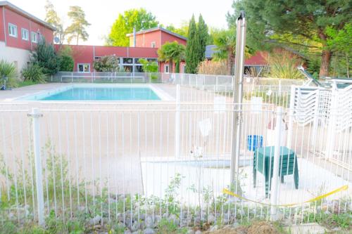 a fence around a swimming pool in a yard at Appartement Shakespeare 15 in Chaveignes