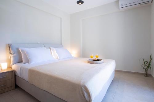 a white bedroom with a bed with two candles on it at Amelie's Luxe Apartments in Lefkada Town