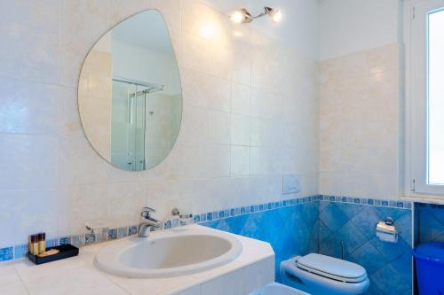 y baño con lavabo, espejo y aseo. en Villa Oliveto apartments, en Oliveto Lario
