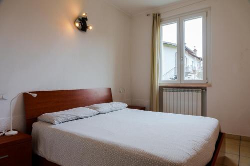 1 dormitorio con cama y ventana en Villa Oliveto apartments, en Oliveto Lario