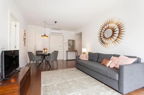 a living room with a gray couch and a television at Lisbon Metro Apartment in Lisbon