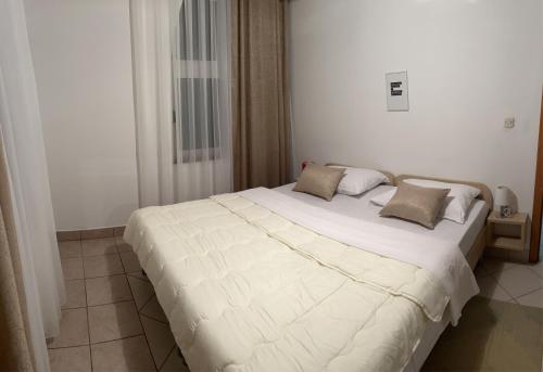 een slaapkamer met een groot wit bed met 2 kussens bij Apartman Antony in Čitluk