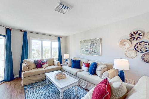 a living room with a couch and a table at Port O'Call C-303 in Isle of Palms