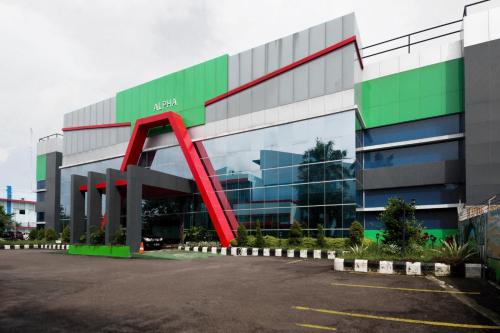 un grand bâtiment avec une arche rouge devant lui dans l'établissement Super OYO Collection O 3431 Hotel Alpha Bandara, à Palembang