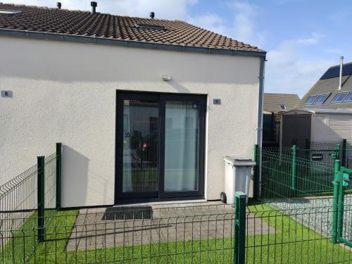 uma casa branca com um portão e uma cerca em SeaBreak4you em Bredene