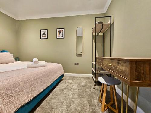 a bedroom with a bed and a desk and a mirror at The Philog by Switchback Stays in Cardiff