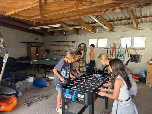a group of people playing a game with a ping pong table at Witbaai Beach House in Britannia Bay