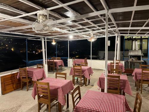 カシュにあるSalina Pansiyonの赤と白のテーブルと椅子が備わるレストラン
