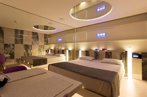 a hotel room with two beds and a television at Nuu Motel in São Paulo