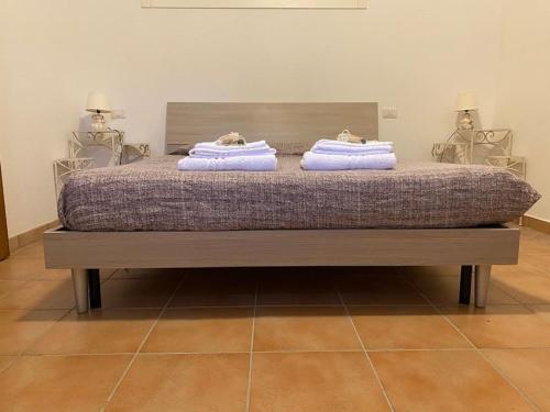 a bed with two towels on top of it at VILLA LIA, casa in collina con piscina. in Porello