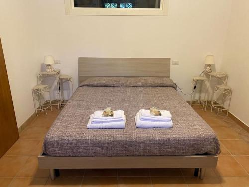 a bedroom with a bed with two towels on it at VILLA LIA, casa in collina con piscina. in Porello