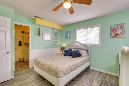 サーフサイド・ビーチにあるWalk to Gulf Surfside Beach Home with Deckの緑の壁のベッドルーム1室、青い枕付きのベッド1台が備わります。