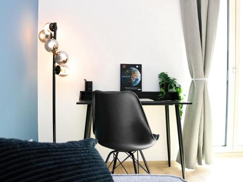 a desk with a chair and a laptop on it in a bedroom at LIGHTPLACE • Design • Boxspring • Balkon • 2 Smart TV •Innenstadt in Braunschweig