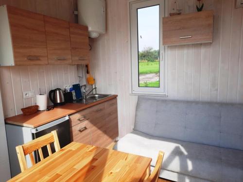 uma pequena cozinha com uma mesa de madeira e uma janela em Gospodarstwo Agroturystyczne Andrzejówka em Gardzień