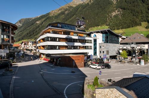 a large building in a town with a mountain at fire & ice LIVING in Ischgl