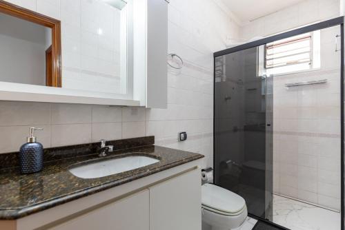 bagno con lavandino, servizi igienici e specchio di Apart Veneza l Garagem l Pet Friendly l Centro de Águas de Lindóia ad Águas de Lindóia