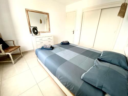 コスタ・テギセにあるSol y Marのベッドルーム(青いベッド1台、鏡、椅子付)