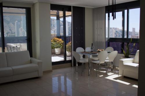 ein Wohnzimmer mit einem Esstisch und Stühlen in der Unterkunft LUXURY Residence Gemelos 26 in Benidorm