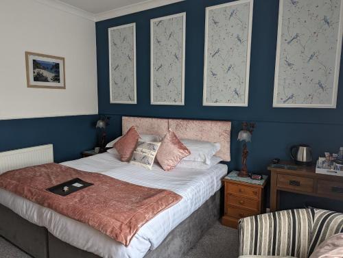 a bedroom with a bed with blue walls at Abingdon House in Torquay