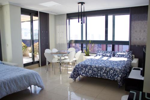 a bedroom with a bed and a table and chairs at LUXURY Residence Gemelos 26 in Benidorm