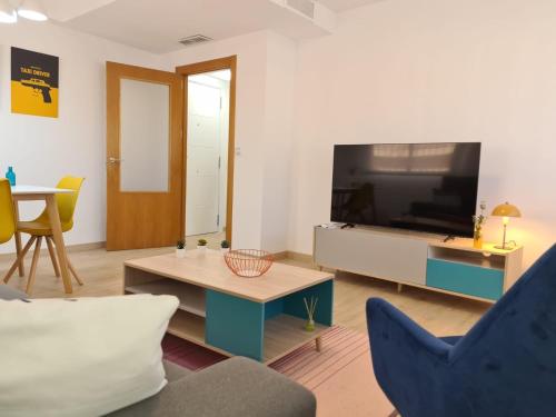 uma sala de estar com uma televisão, um sofá e uma mesa em Magnifico apartamento nuevo La Alberca em Múrcia